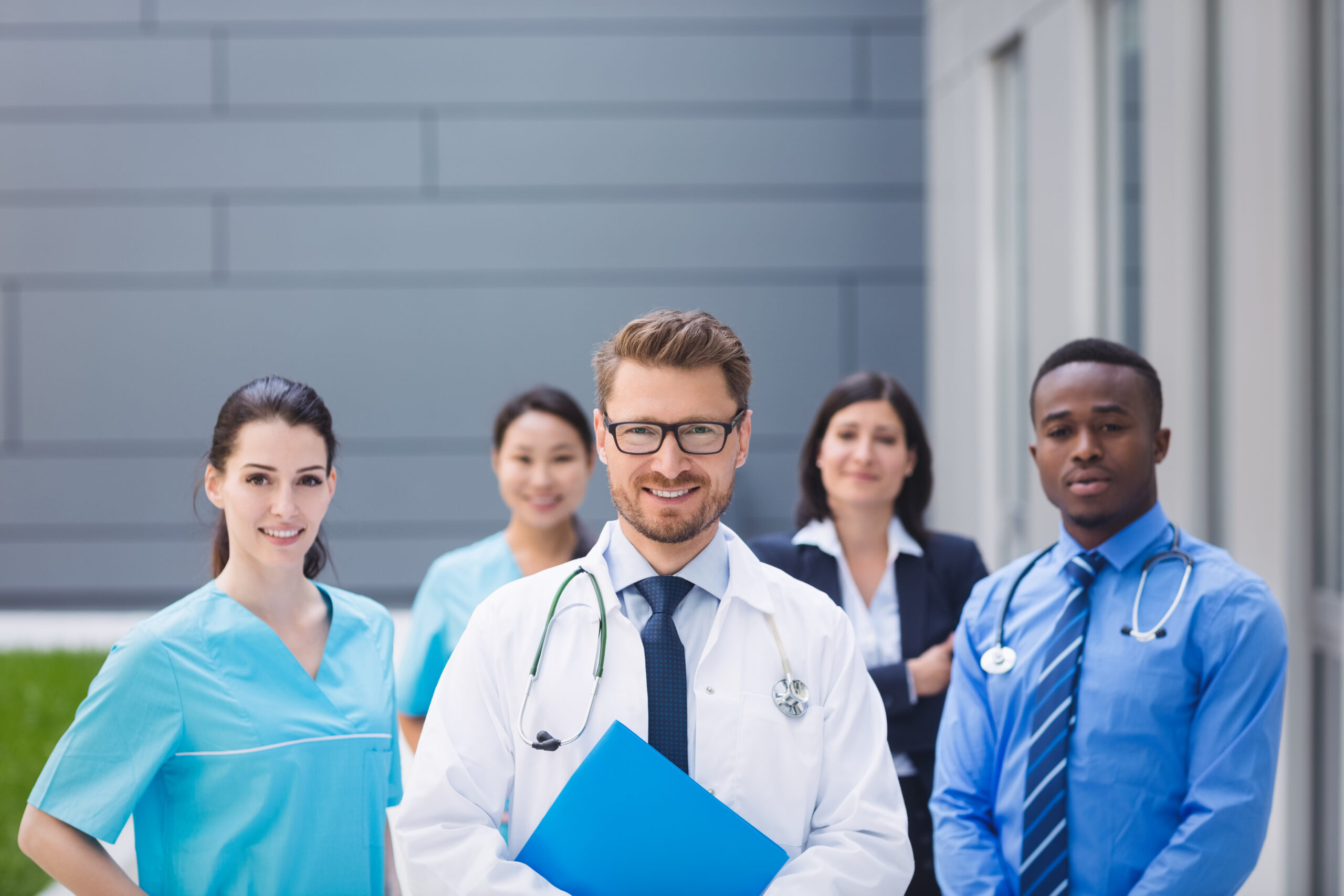 Portrait of smiling doctors standing together in hospital premises Portrait of smiling doctors standing together in hospital premises
